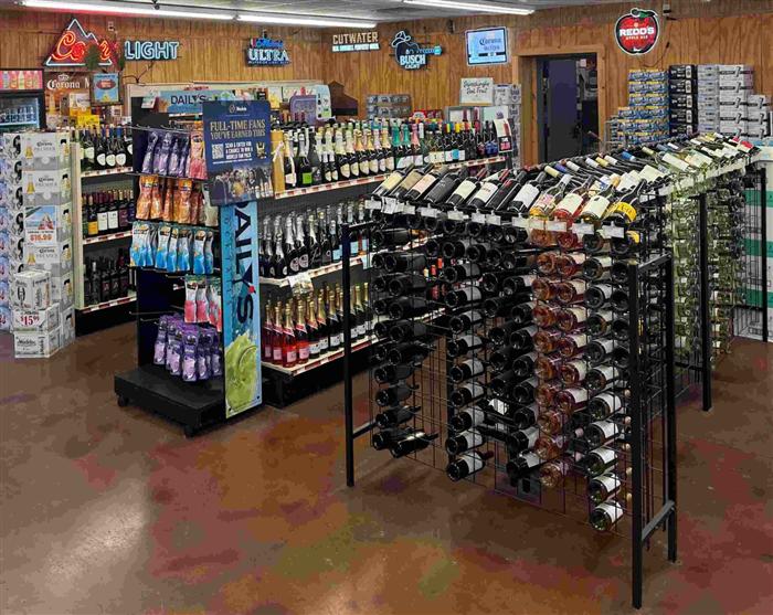 Beer aisle and 24-pack case display inside AJ's Beer, Wine & Spirits