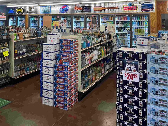 Liquor aisle and beer case display inside AJ's Beer, Wine & Spirits